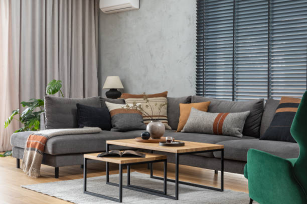 istock Stylish composition of elegant living room interior with grey corner sofa, coffee table and stylish personal accessories. Modern home decor. Panoramic windows. Template. 1384255895
