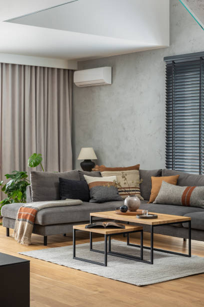 istock Creative composition of elegant living room interior with grey corner sofa, coffee table and stylish personal accessories. Modern home decor. Panoramic windows. Template. 1384255937