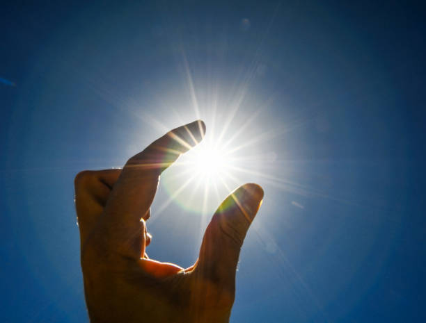 istock One Hand Catching the Sun Stars on a Blue Background 1384256893