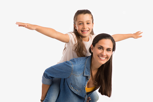 Mother giving her Daughter a ride On her back while playing