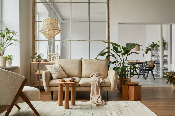 istock Modern living room interior composition with beige sofa, wooden coffee table and modern home accessories. Template. Copy space. Dining room in the background. 1384257131