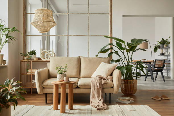 istock Modern living room interior composition with beige sofa, wooden coffee table and modern home accessories. Template. Copy space. Dining room in the background. 1384257463