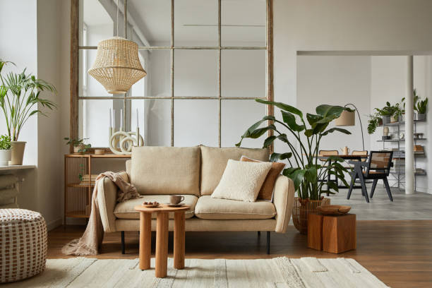 istock Modern living room interior composition with beige sofa, wooden coffee table and modern home accessories. Template. Copy space. Dining room in the background. 1384257699
