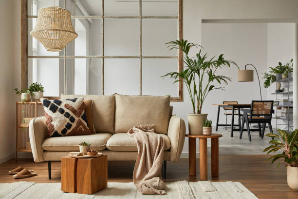istock Elegant living room interior design with beige modern sofa, coffee table and creative accessories. Template. Copy space. Dining room in the background. 1384257723