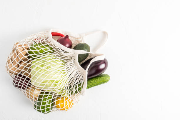 istock a white string bag filled with fresh vegetables on a white background. top view. the concept of vegan food and shopping without plastic packaging. 1384257991