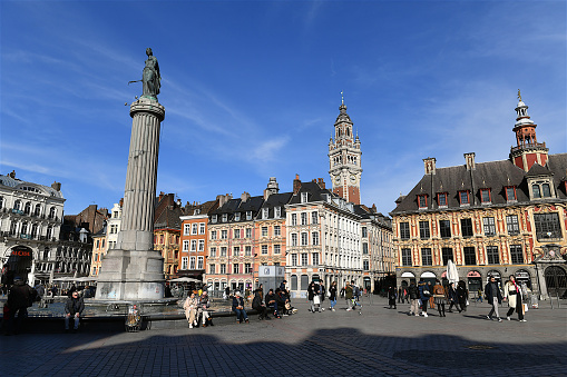 Lille, France-02 28 2022: People on the Lille central square.The Column of the Goddess is the popular name given by the citizens of Lille (France) to the Memorial of the Siege of 1792. The memorial is still in the center of the Grand′ Place (central square) of Lille, and has been surrounded by a fountain since around 1990.