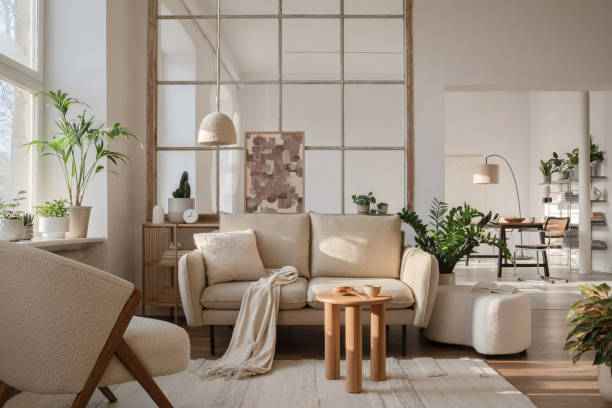 istock Modern living room interior composition with beige sofa, wooden coffee table and modern home accessories. Template. Copy space. Dining room in the background. 1384258143