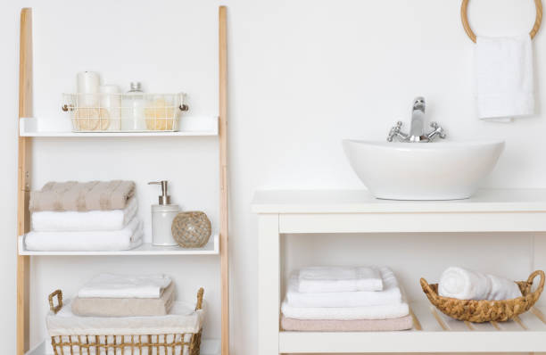 Bathroom shelves with towels and spa products in light interior stock photo