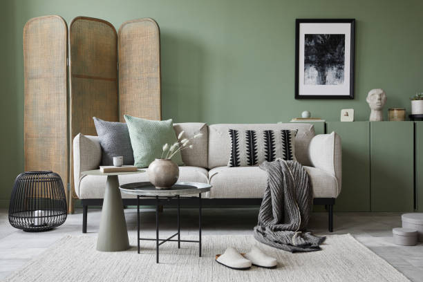 istock Elegant living room interior design with mockup poster frame, modern grey sofa, wooden commode, folding screen and stylish accessories. Eucalyptus green wall. Template. Copy space. 1384260550