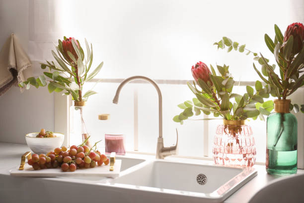 istock Vases with beautiful protea flowers near sink in kitchen. Interior design 1384261706