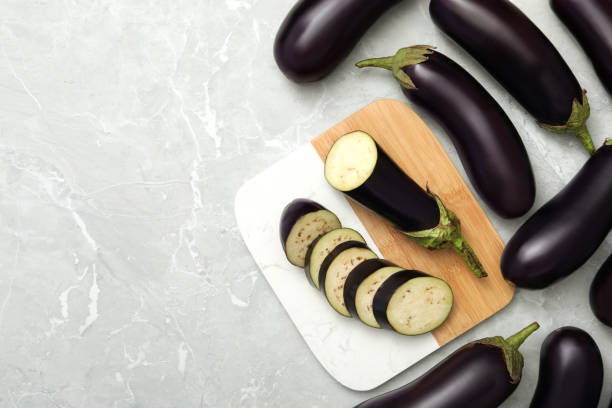 istock Cut and whole raw ripe eggplants on grey table, flat lay. Space for text 1384261707