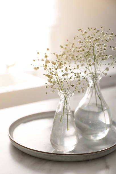 istock Vases with gypsophila flowers on table in kitchen. Interior design 1384261714