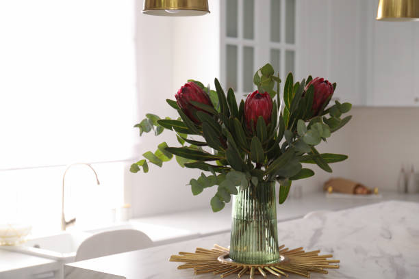 istock Bouquet with beautiful protea flowers on table in kitchen. Interior design 1384261775