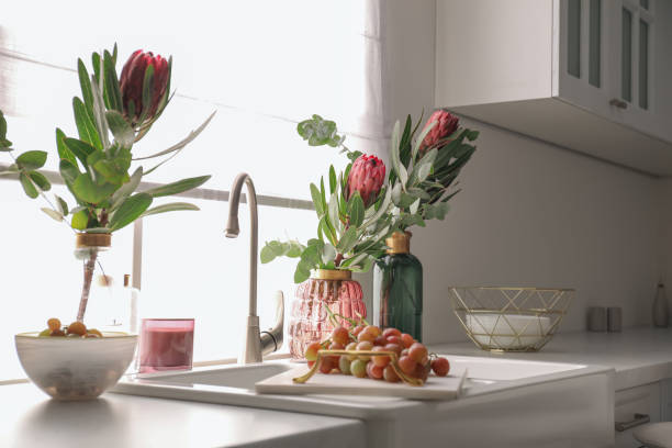 istock Vases with beautiful protea flowers near sink in kitchen. Interior design 1384261864