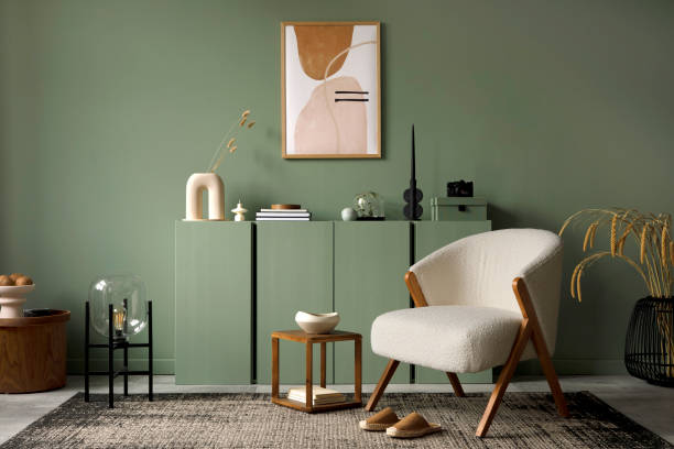 Stylish living room interior design with mock up poster frame, frotte armchair, wooden commode, side table, plants and creative home accessories. Eucalyptus wall. Home staging. Template. Copy space. stock photo