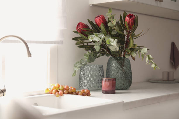 istock Bouquet with beautiful protea flowers on countertop in kitchen. Interior design 1384261877