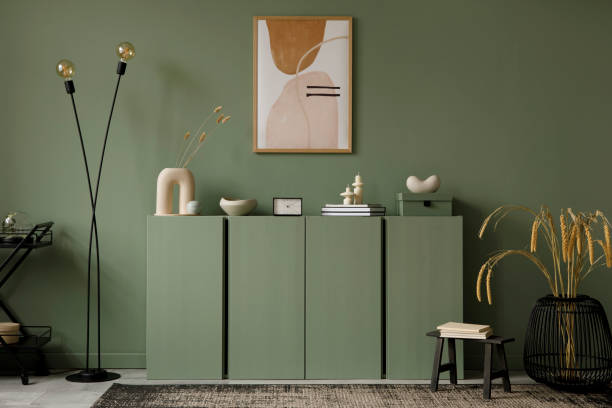 istock Modern living room interior composition with mockup poster frame, sage green wooden commode and modern home accessories. Eucalyptus wall. Home staging. Template. Copy space.