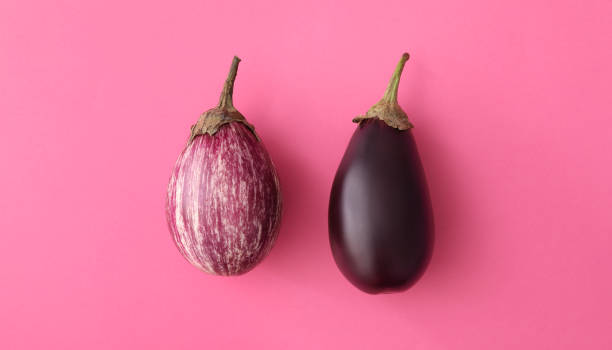 istock Raw ripe eggplants on pink background, flat lay 1384262143