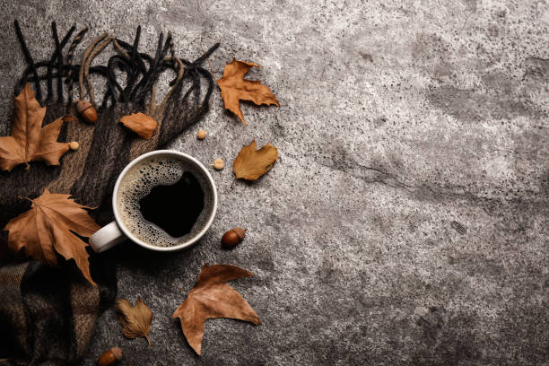 istock Flat lay composition with cup of hot drink and autumn leaves on grey table, space for text. Cozy atmosphere 1384262304