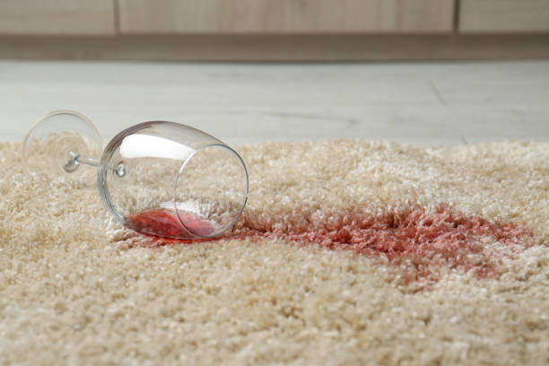 istock Overturned glass and spilled red wine on soft carpet 1384262349