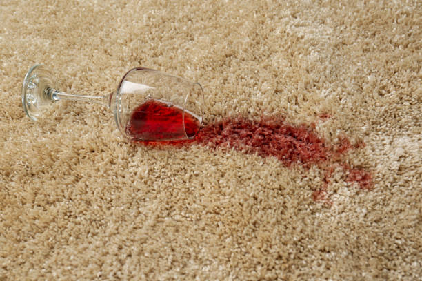 istock Overturned glass and spilled red wine on soft carpet 1384262356