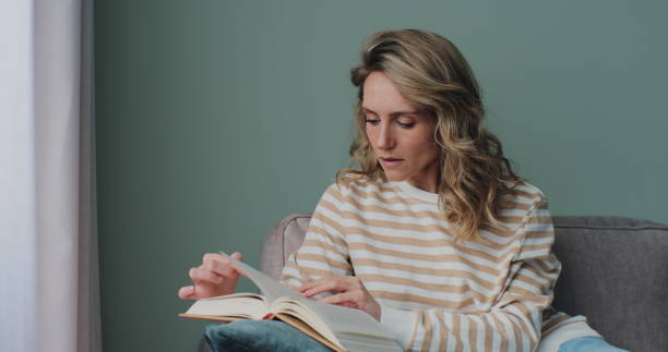 istock Female or student enjoying entertainment literature or educational textbook. Learning, studying, education, read books, stay home concept. 1384264350