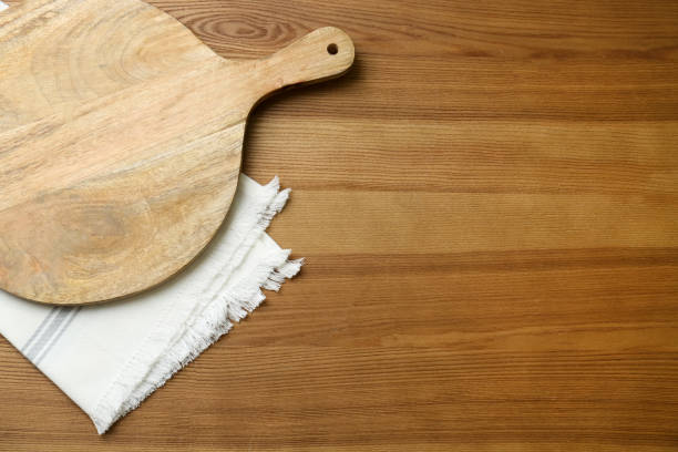 istock Empty wooden board and napkin on table, top view. Space for text 1384264505