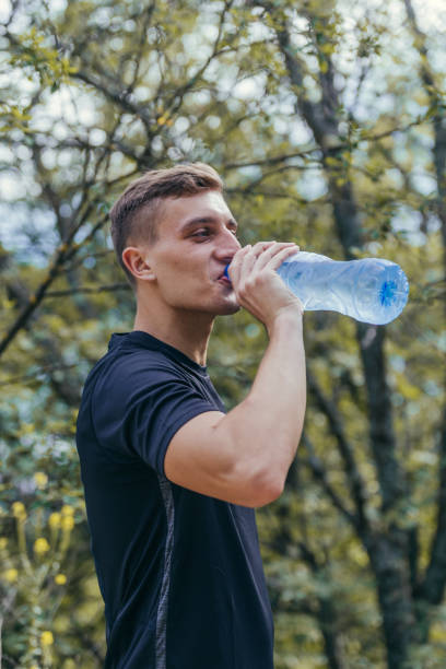 istock Male athlete drinking water, refreshing, hydrating after a long exhausting workout, run. 1384265450