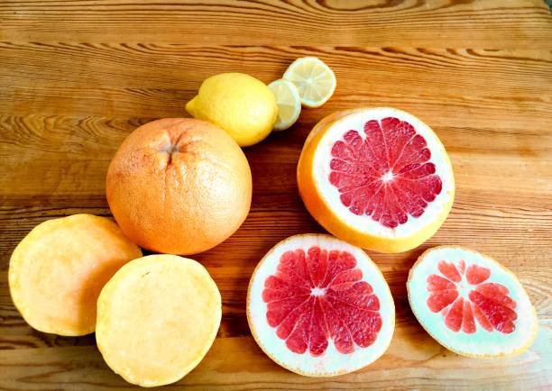 Citrus grapefruit and lemon slices on wooden background stock photo