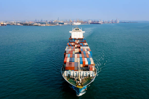 istock Aerial front view container cargo ship carrying commercial container import export business delivery service commerce cargo logistic and transportation international by container ship in green sea worldwide 1384265742