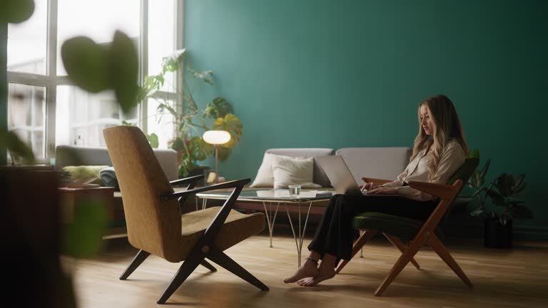 Woman typing on her laptop in the living room