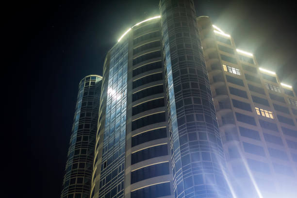 Bottom angle shooting  modern urban building with neon light against the night sky