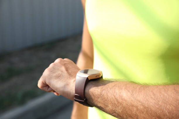 istock Man checking fitness tracker after training outdoors, closeup 1384268481