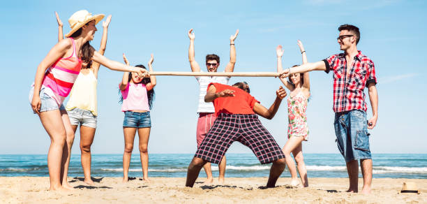 Multicultural friends group having fun together with limbo game at beach vacation - Summer joy life style concept with young multi ethnic people playing on spring break vacation - Bright filter grupo de amigos multiculturales divirtiéndose junto con el juego de limbo en las vacaciones en la playa - concepto de estilo de vida de alegría de verano con jóvenes multiétnicos jugando en vacaciones de vacaciones de primavera - filtro brillante
