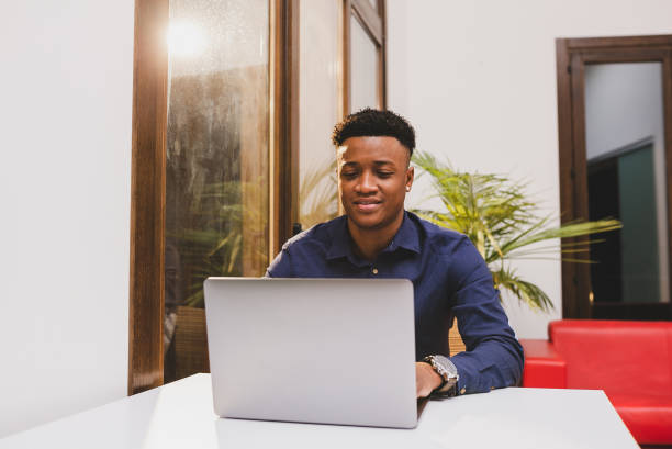 istock Handsome African american guy using laptop for wotk in a coworking. 1384274517