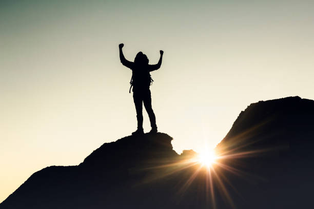 istock Man with arms raised at sunset 1384275827