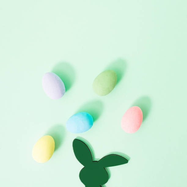istock Rabbit is thinking about Easter Holiday with colorful eggs above his head  on pastel green background with copy space for text. Minimal Easter concept with bunny and colored egg for upcoming season. 1384276459