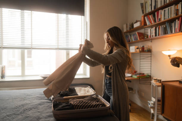 istock Woman packing clothes in a bag for a trip 1384277288