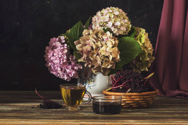 istock Still life with hydrangea, a cup of tea and elderberry jam on a wooden table 1384277731