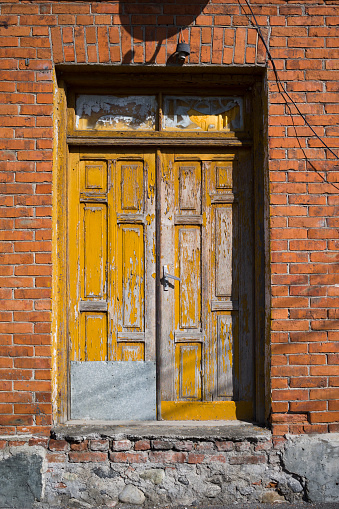 Vertical shot of Old Yellow wooden door