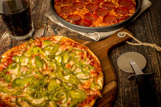 istock Green pepper pizza and Pepperoni pizza on wood table 1384278807