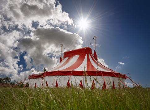 Striped circus red big top with waving flags , Lugo city, Galicia, Spain.Sky background.