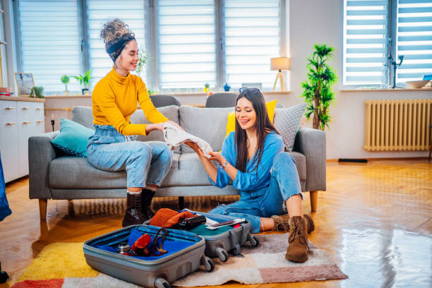 istock Female friends packing suitcase for vacation 1384282137