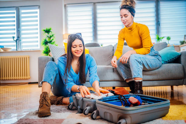 istock Girlfriends packing clothing into a suitcase 1384282296