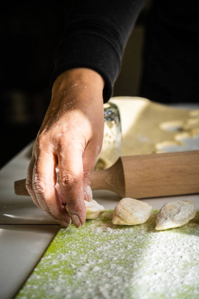 istock Womens hands making dumplings with dough and mashed potato. Female hands in flour, the process of cooking ukrainian vareniki. 1384285859