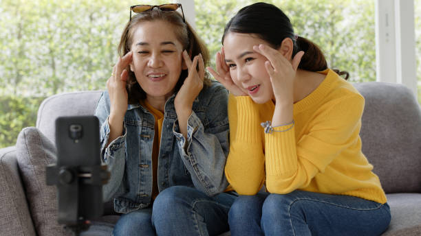 Asia senior parent and girl in Mom day joy play music recording vlog viral shooting on social media app IG reel story tiktok at home love warm good time. Child teen enjoy fun life relax smile laugh. padre y niña mayores de asia en el día de la mamá alegría play música grabación vlog viral disparo en la aplicación de redes sociales ig reel story tiktok en casa amor cálido buen momento. niño adolescente disfrutar de la vida divertida relajar so