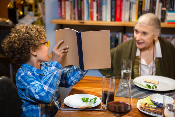 kleiner junge zeigt auf die haggada am pessach-seder - seder passover judaism family stock-fotos und bilder