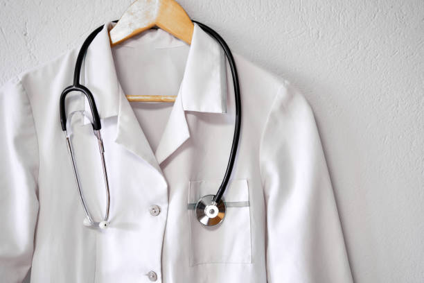 istock Doctor's white coat with stethoscope over white background with copy space. 1384288242