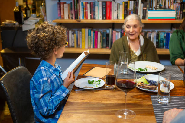 piccolo ragazzo che legge da haggadah - seder passover judaism family foto e immagini stock