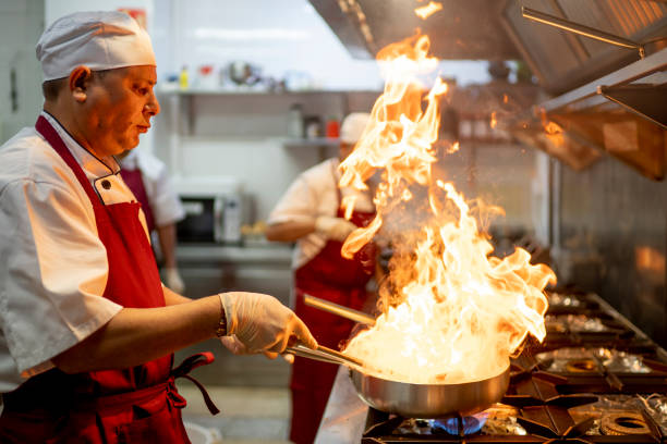 istock Indian chef cooking in industrial kitchen with the burning pan 1384288440